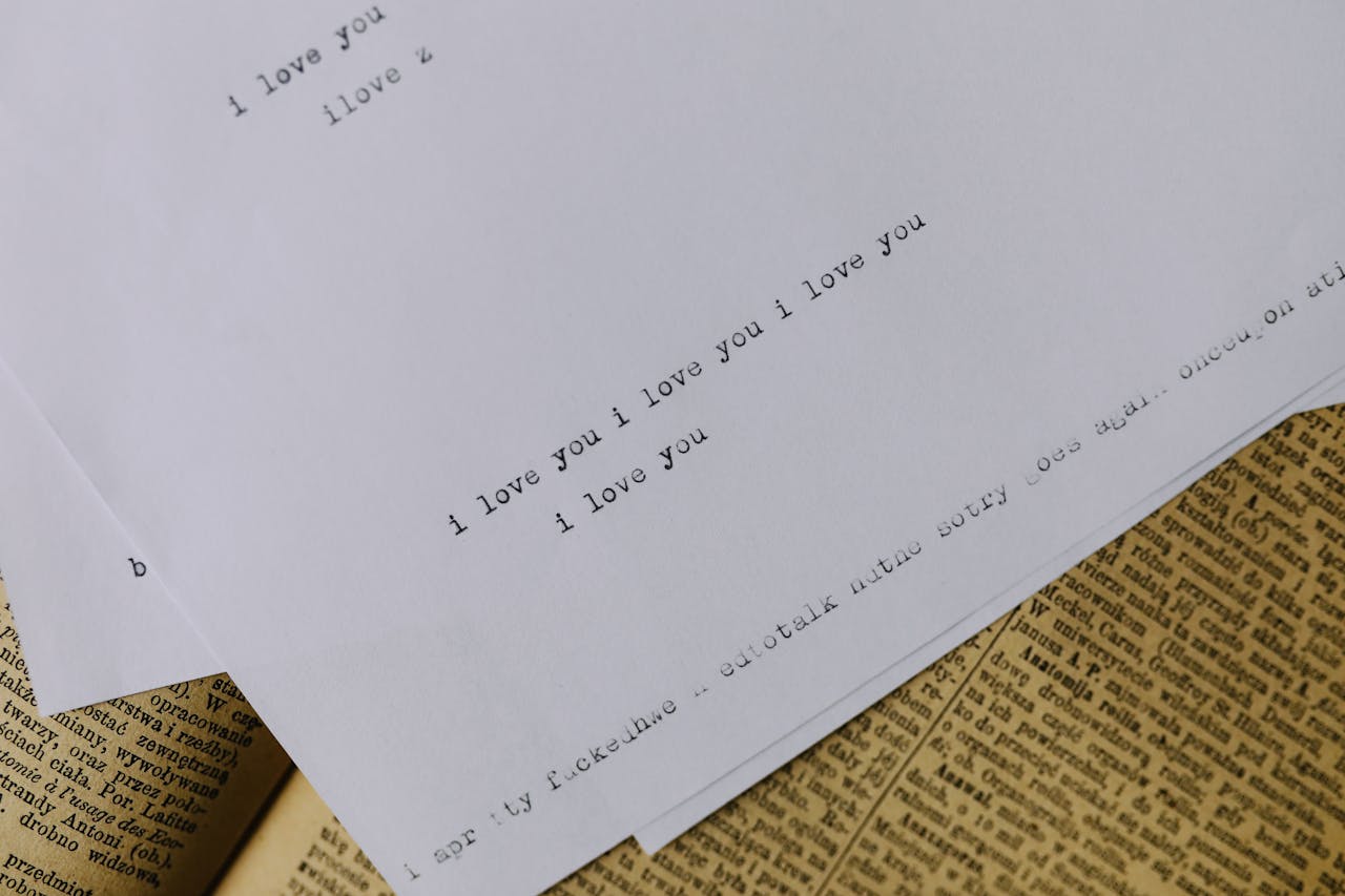 Typewritten note with I love you on vintage paper background, evoking nostalgia.
