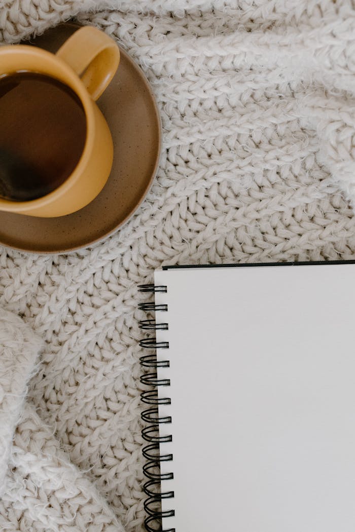 Mastering the First Impression: Your intriguing post title goes here Warm coffee cup on a knitted blanket beside an open notebook, ready for inspiration.